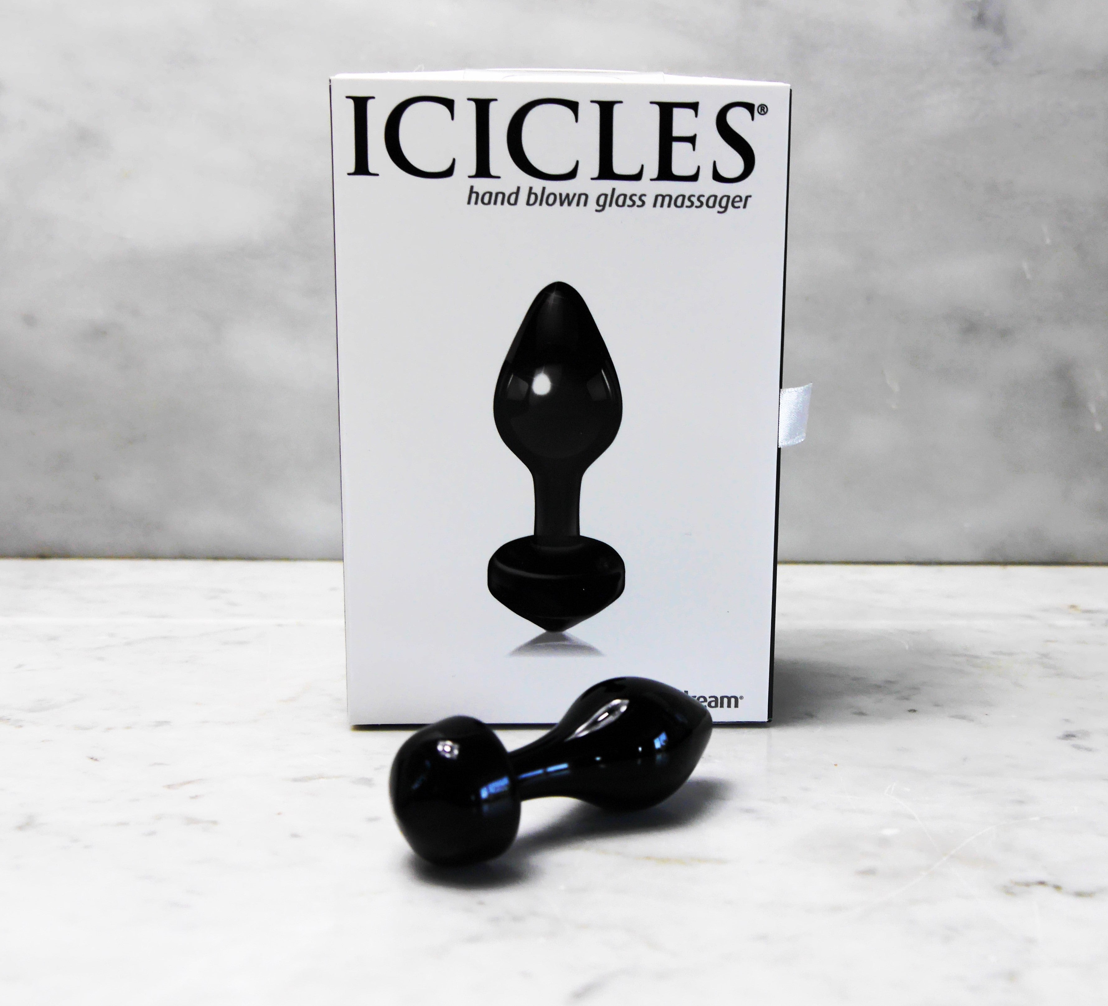 Handgeblazen glazen buttplug Icicles, zwart, met witte verpakking op marmeren ondergrond.