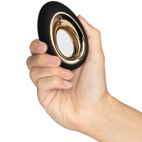 Hand houdt zwarte LELO Alia vibrator vast met compact eivormig design en gouden ring