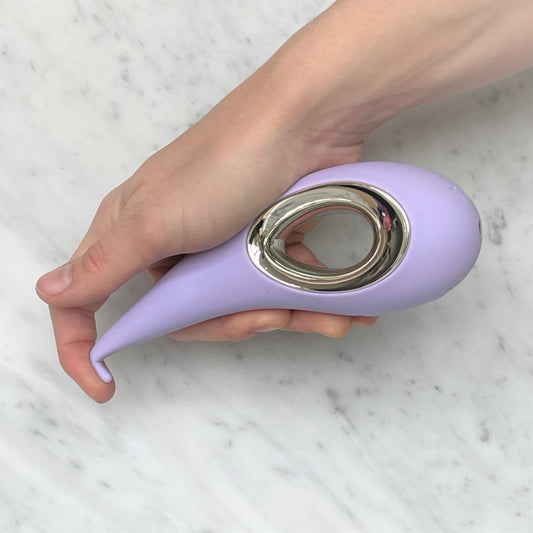 Dot clitorisstimulator van Lelo in lavendel vastgehouden in hand, compact formaat