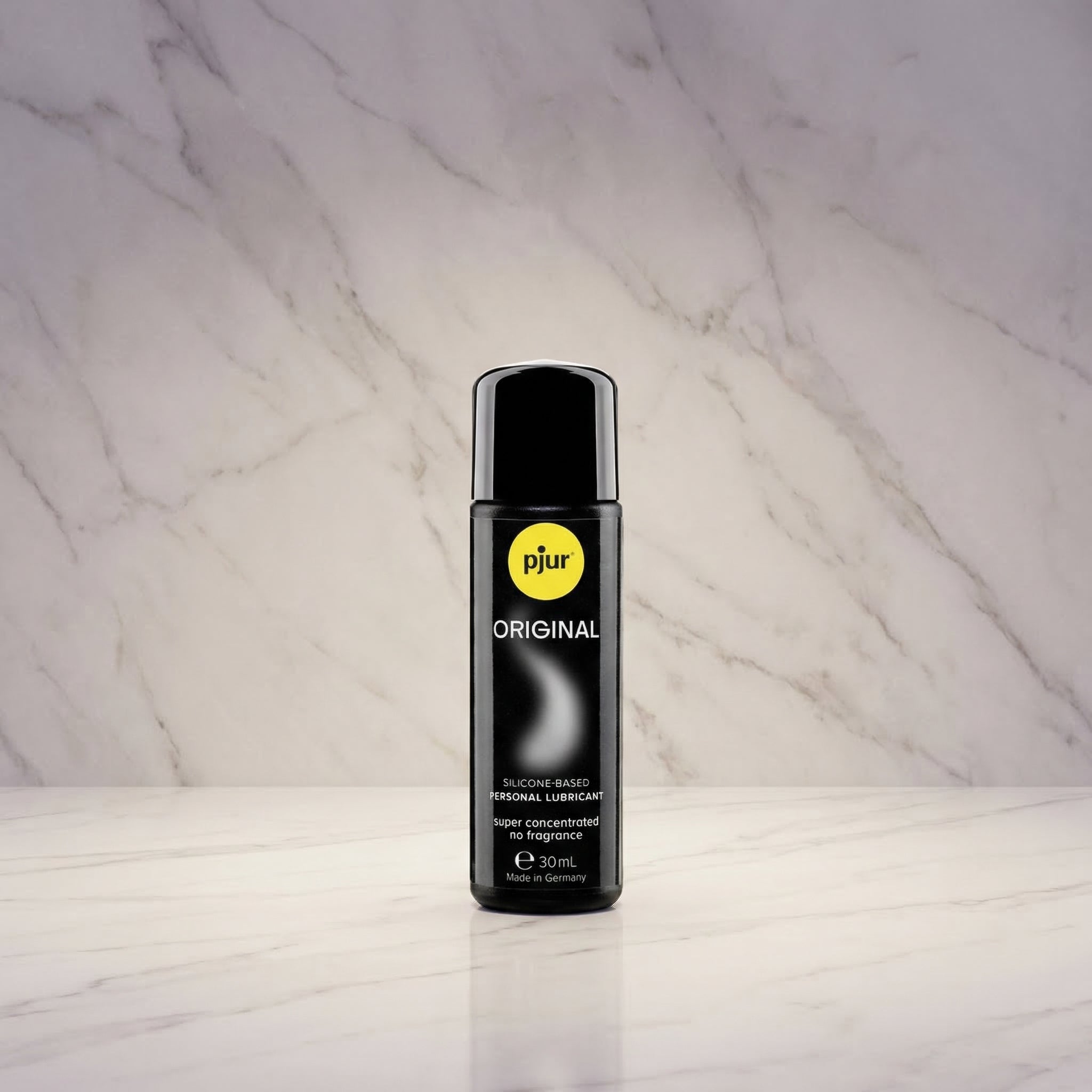 Pjur Original siliconenbasis glijmiddel 30 ml reisformaat, zwarte fles tegen marmeren achtergrond